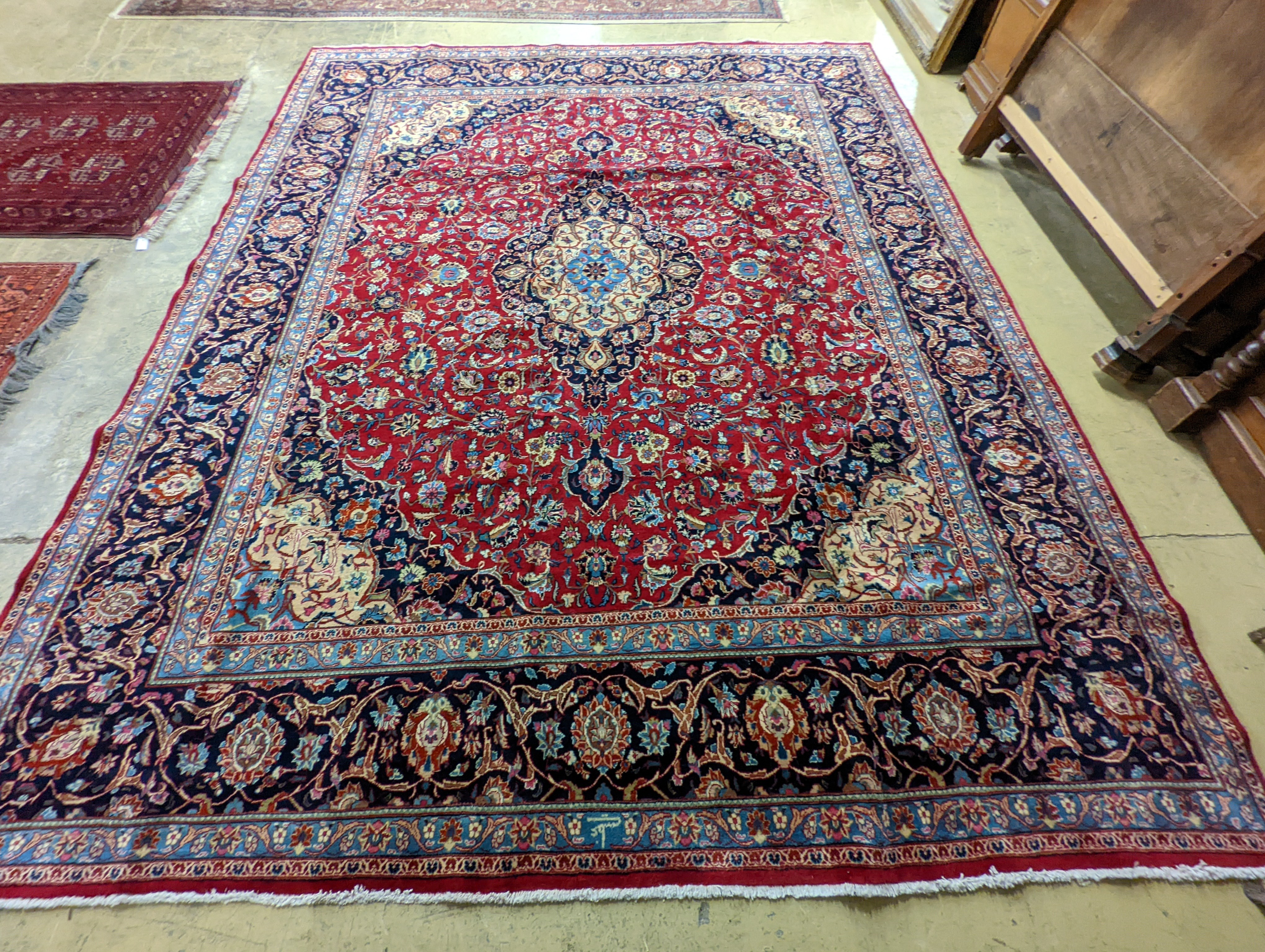 A Kashan burgundy ground carpet, 380 x 300cm